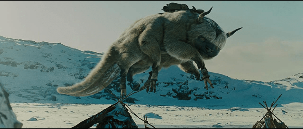 Appa, a flying bison, floats in the air as several children hang on to his legs. A snowy landscape is visible around them.